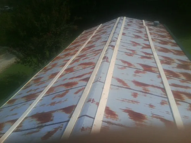 Rusted metal roof panels with new wood purlins before replacement — Storm Damage Roof Repair in Livonia by Roofing Brothers