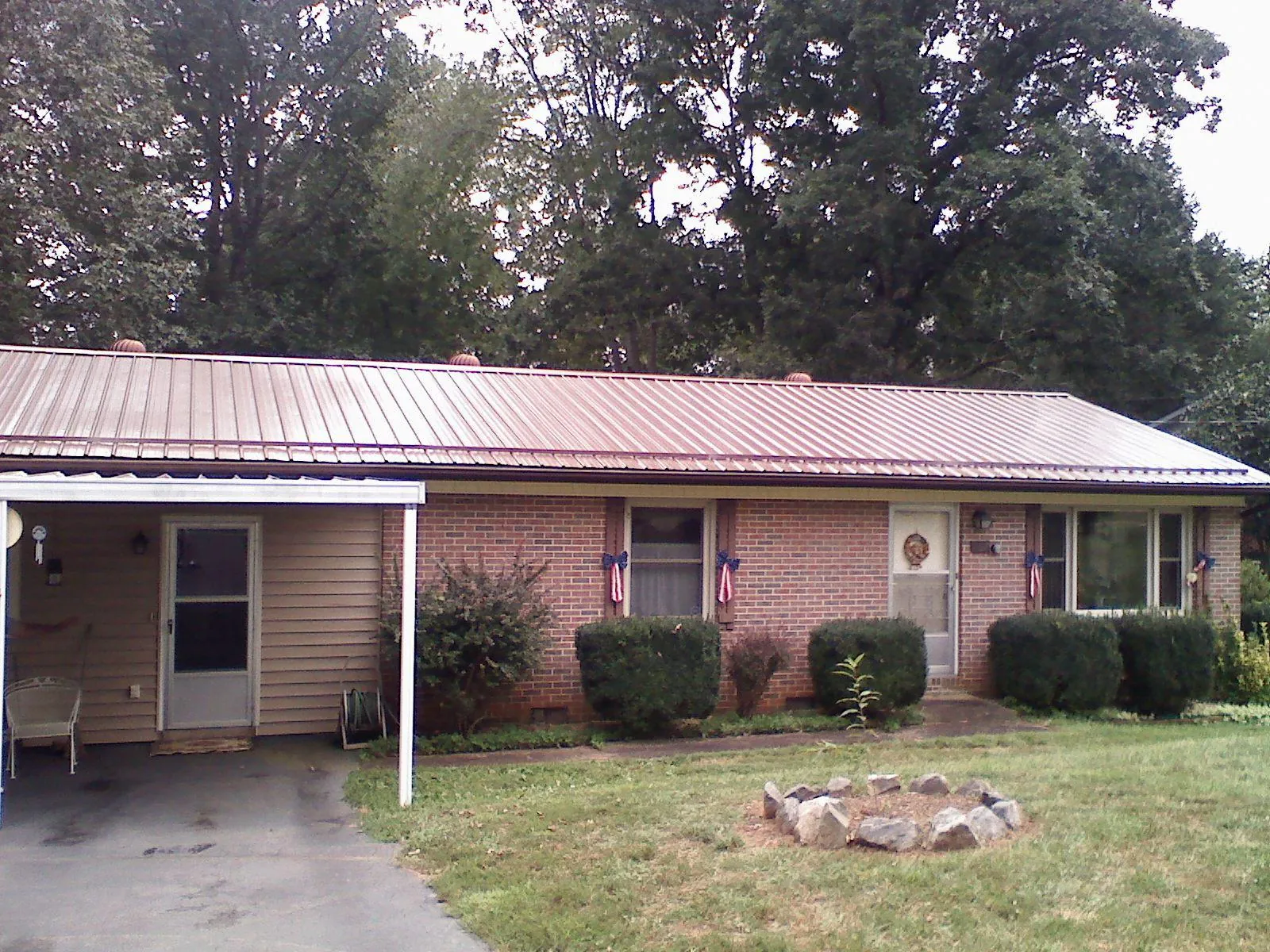 Bronze metal roof and carport on a brick ranch home — Roof Repair work by our crew in Livonia